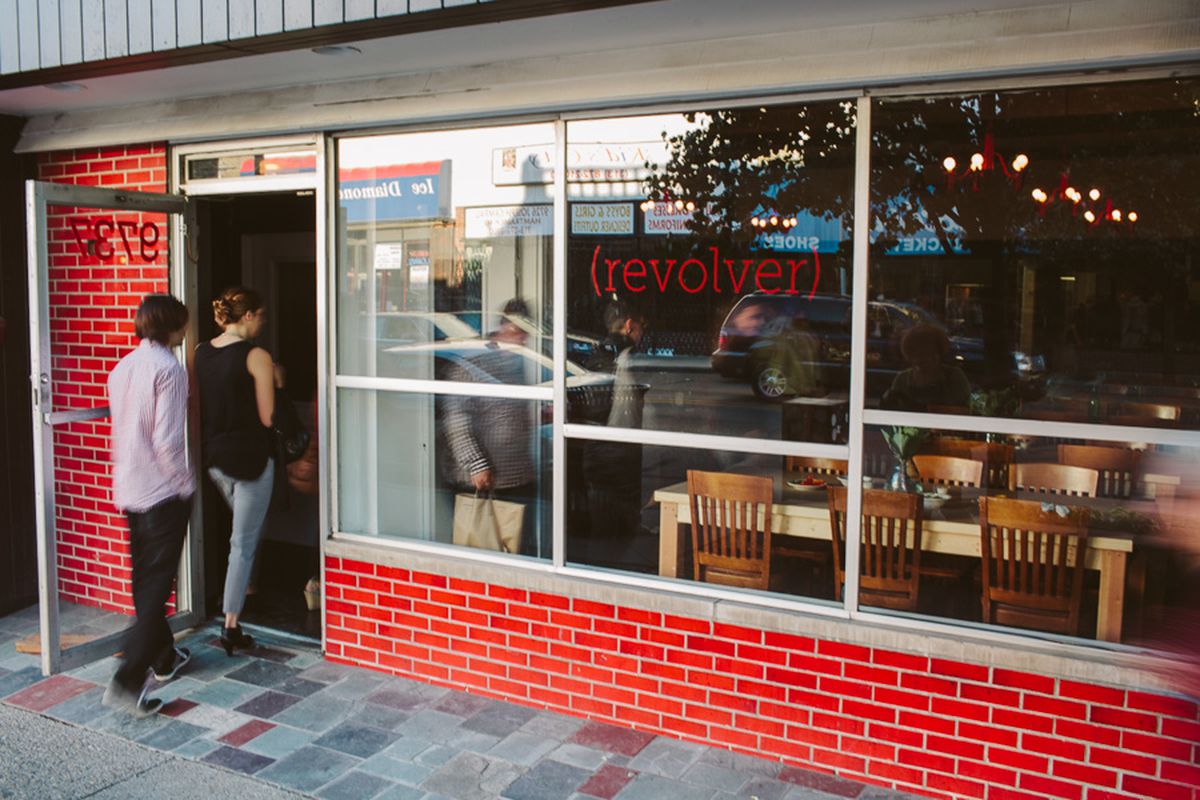 Two customers walk through the doors of Revolver’s red-tiled storefront. 