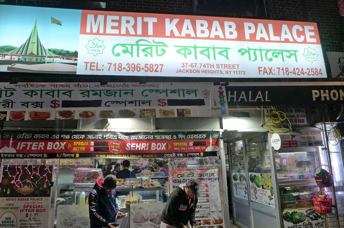 A well lit facade by night with a picture of a Bangladeshi mosque on the sign.