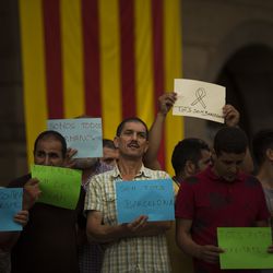 Members of the local Muslim community gather along with relatives of young men believed responsible for the attacks in Barcelona and Cambrils to denounce terrorism and show their grief in Ripoll, north of Barcelona, Spain, Sunday Aug. 20, 2017. Sheets read in Catalan: "We all are Barcelona", "This affects all of us", "Not in the name of Islam" and "Everybody against terrorism". (AP Photo/Francisco Seco)