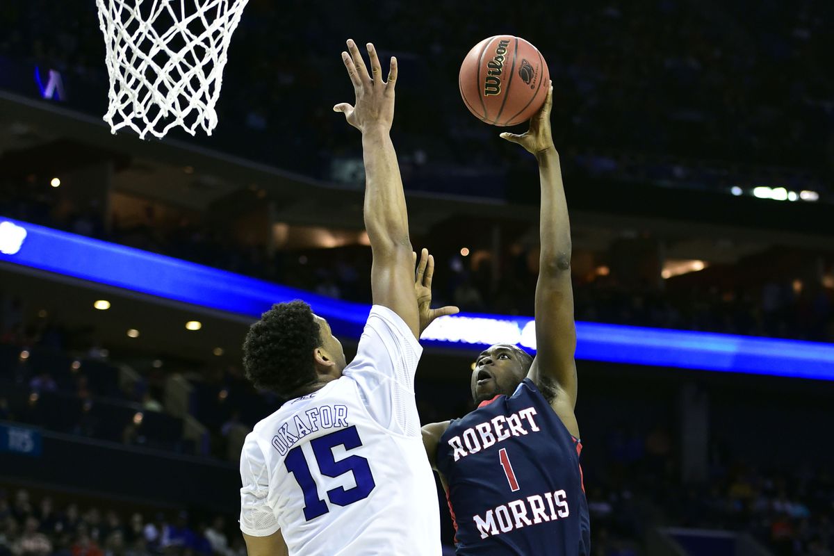 Mar 20, 2015; Charlotte, NC, USA; Robert Morris Colonials forward Lionel Gomis (1) shoots the ball against Duke Blue Devils center Jahlil Okafor (15) during the second half in the second round of the 2015 NCAA Tournament at Time Warner Cable Arena.