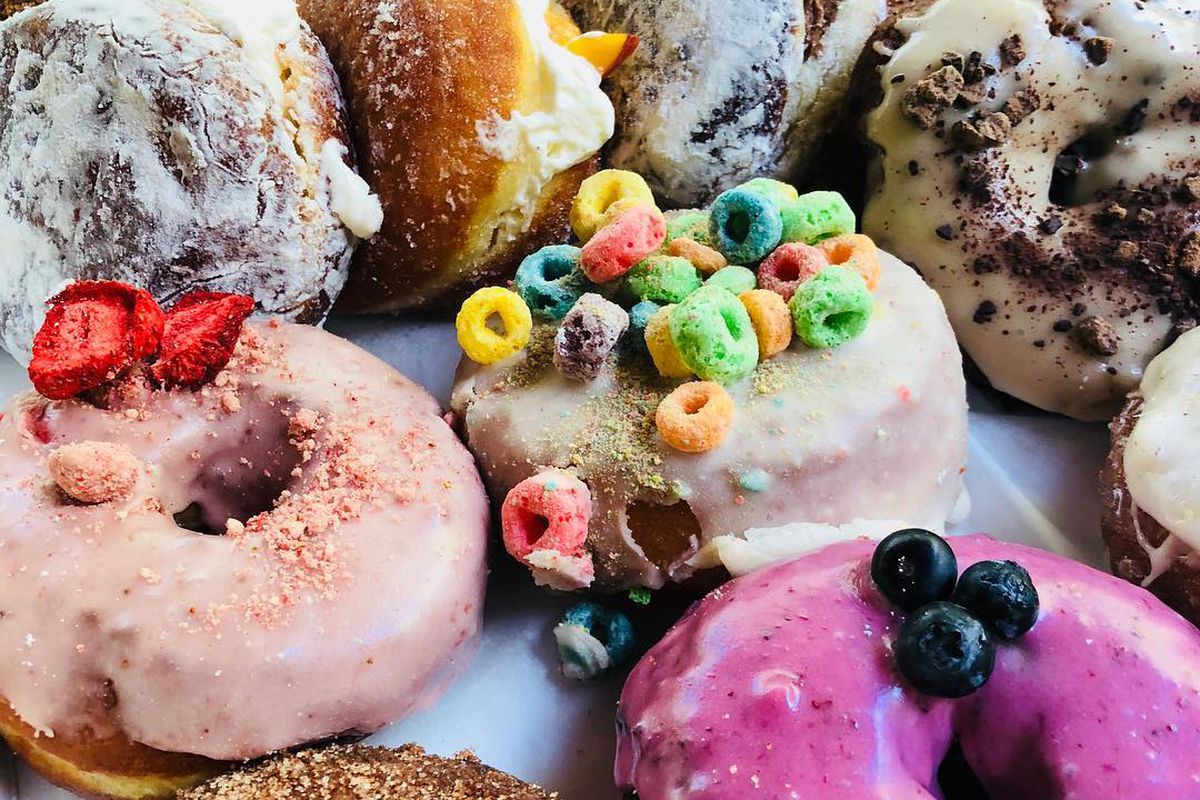 A selection of colorful selection of frosted and sugared cake and filled doughnuts from Doughnut Dollies in Atlanta