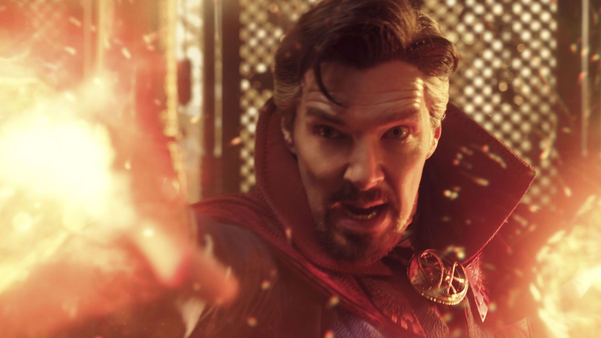 Benedict Cumberbatch as Doctor Strange blasts sheets of glowy orange frap out of his hands in Doctor Strange in the Multiverse of Madness.