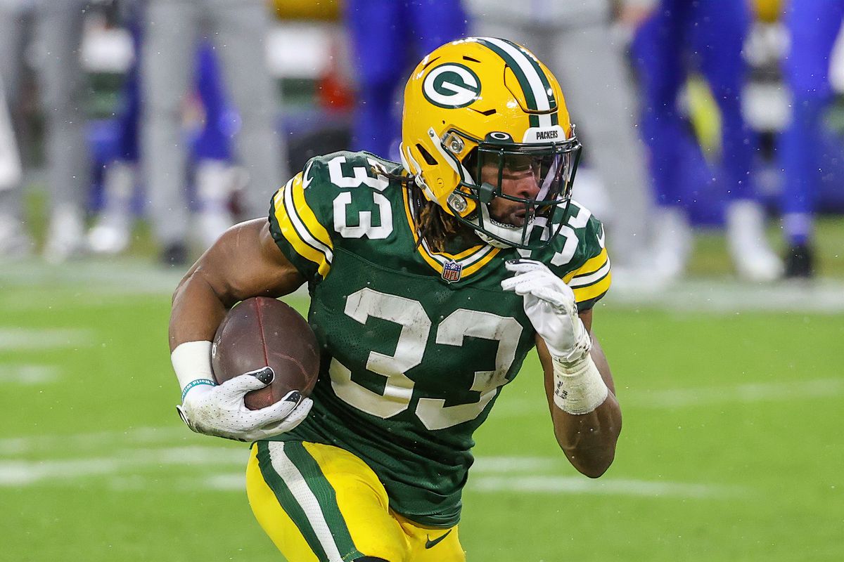 Aaron Jones #33 of the Green Bay Packers runs with the ball in the second quarter against the Los Angeles Rams during the NFC Divisional Playoff game at Lambeau Field on January 16, 2021 in Green Bay, Wisconsin.