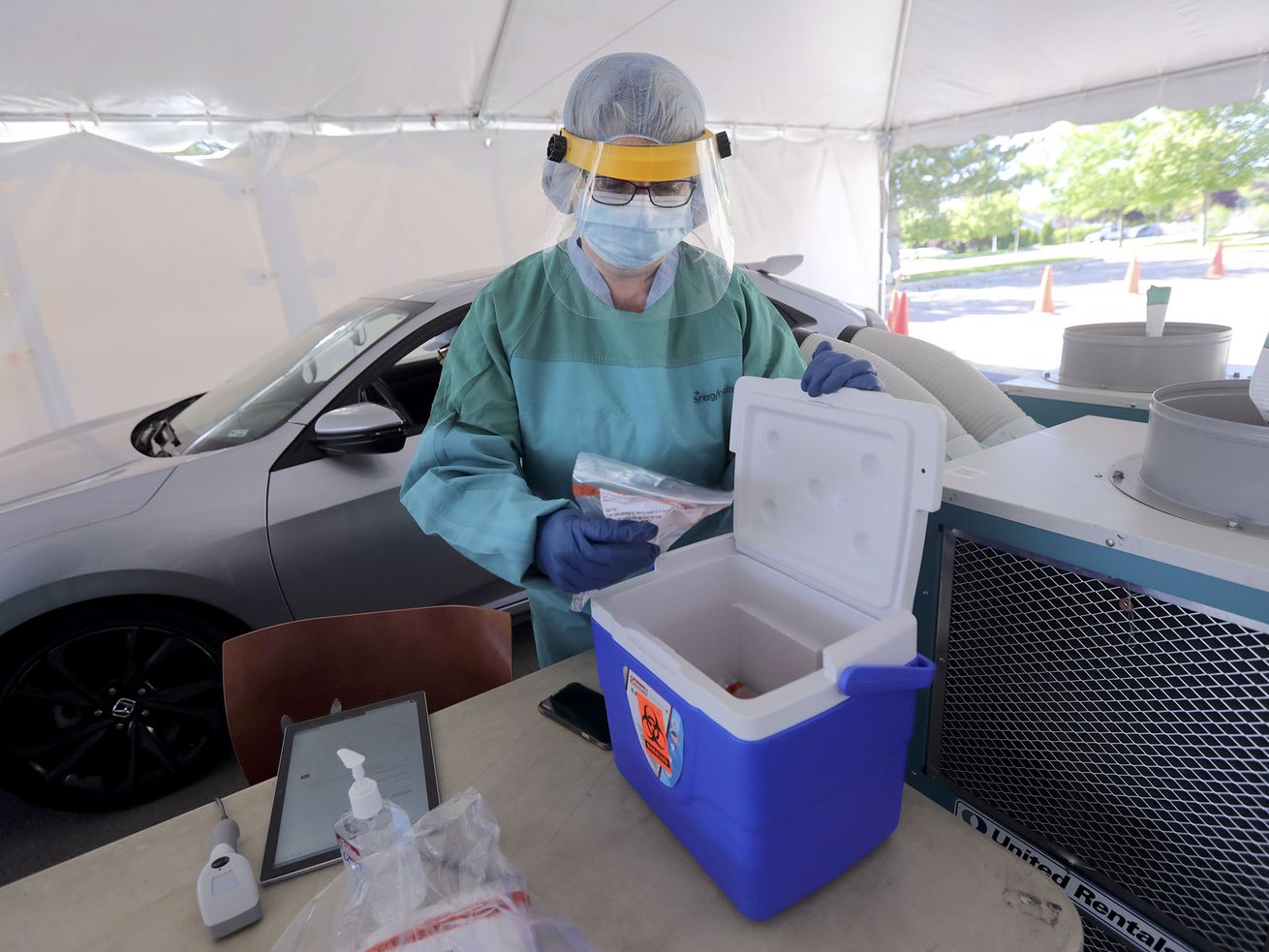 Cassandra Stockwell, a registered nurse, stores a testing sample while giving COVID-19 tests at a TestUtah testing site outside of Timpanogos Regional Hospital in Orem on Thursday, May 28, 2020.