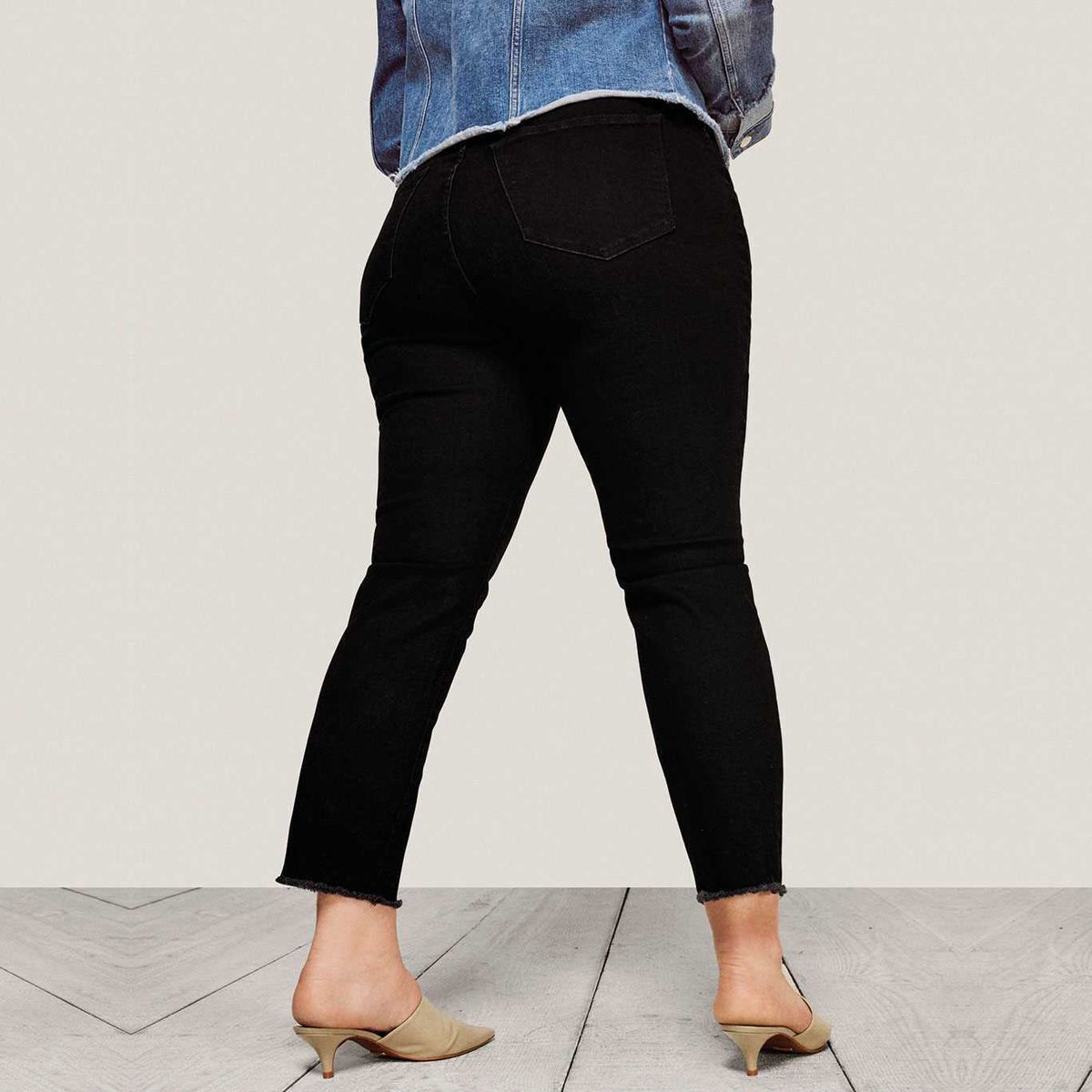 A model wearing black straight leg jeans and a denim jacket