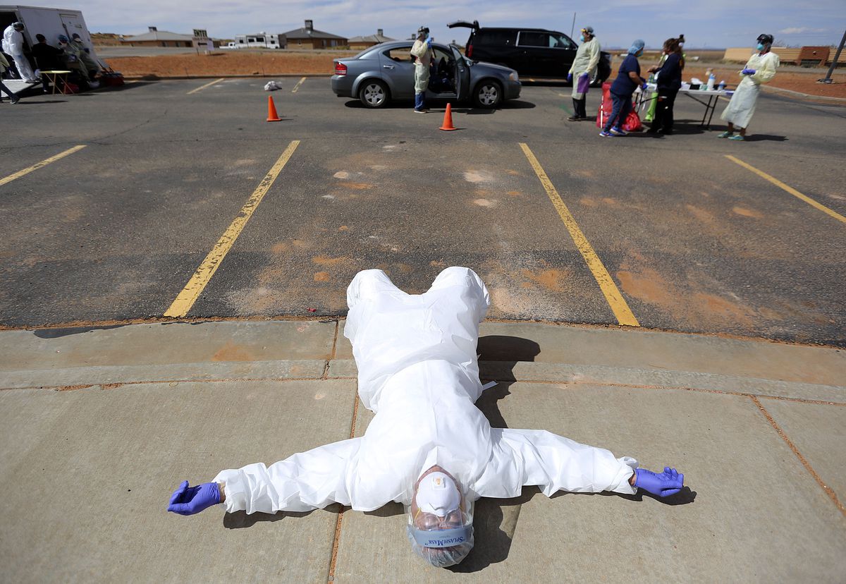 Andy Byrnes, a contracted emergency medical technician with the Utah Department of Health, rests on the sidewalk near the end of a second day of testing for COVID-19 outside of the Monument Valley Health Center in Oljato-Monument Valley, San Juan County, on Friday, April 17, 2020. The mobile testing team tested 1,060 people in two days.