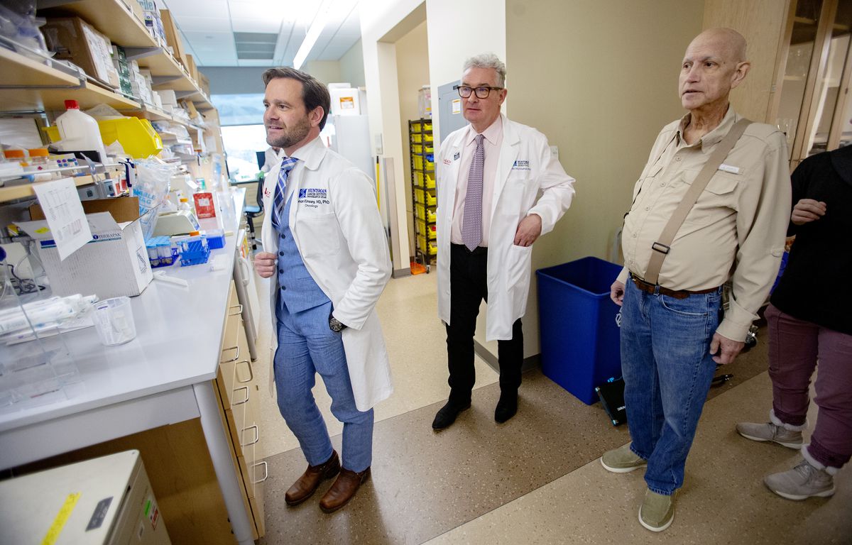Dr. Conan Kinsey, a physician-scientist at the Huntsman Cancer Institute, left, and Martin McMahon, a cancer researcher at the institute and professor of dermatology at the University of Utah, talk with Gordon Chamberlain, Kinsey's patient, about about a 
