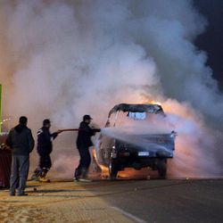 Firefighters try to extinguish a fire on a truck as a riot broke out outside of a major soccer match between Egyptian Premier League clubs Zamalek and ENPPI at Air Defense Stadium in a suburb east of Cairo, Egypt, Sunday, Feb. 8, 2015. The riot broke out between the Egypt security forces and Zamalek fans outside of the major soccer game at the stadium, violence that killed at least 20 people, security officials said. 