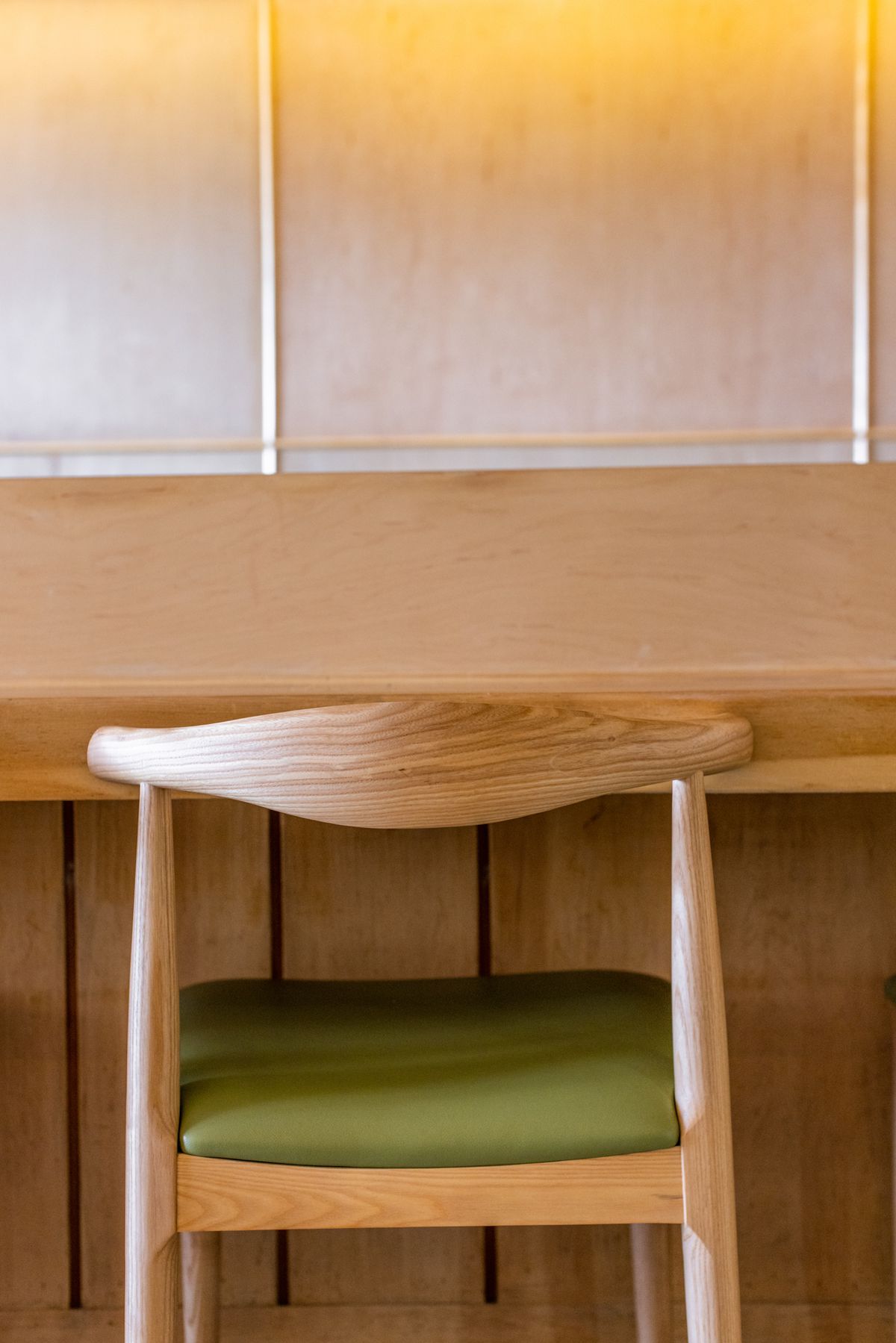 Wood-lined counter with pale green leather seat.