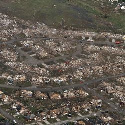 This aerial photo shows the remains of homes hit by a massive tornado in Moore, Okla., Monday May 20, 2013. A tornado roared through the Oklahoma City suburbs Monday, flattening entire neighborhoods, setting buildings on fire and landing a direct blow on an elementary school.