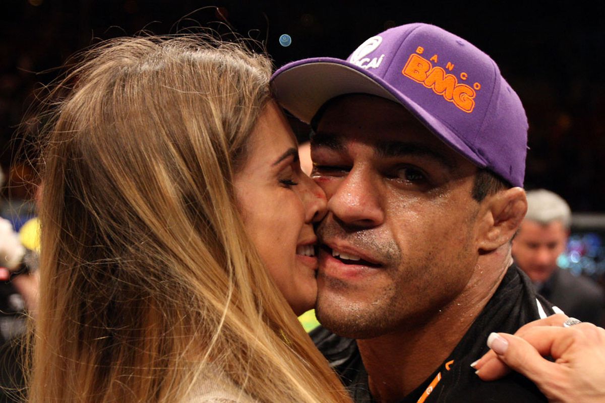 Vitor Belfort mugs for the camera while his wife, Joana Prado, kisses him following his submission victory over Anthony Johnson at UFC 142 on Sat., Jan. 14, 2012, at the HSBC Arena in Rio de Janeiro, Brazil. Photo by Josh Hedges via Getty Images. 