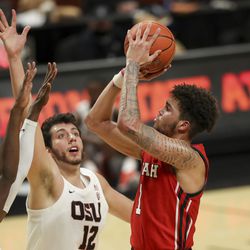 Utah’s Timmy Allen (1) shoots over Oregon State’s Warith Alatishe, left, and Roman Silva (12) during the first half of an NCAA college basketball game in Corvallis, Ore., Thursday, Feb. 18, 2021.