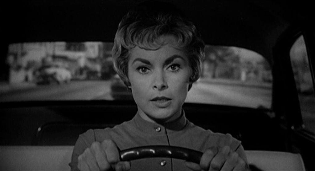 A woman (Janet Leigh) behind the wheel of an automobile in Psycho.
