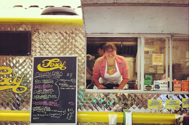 A woman stands in a food truck window 