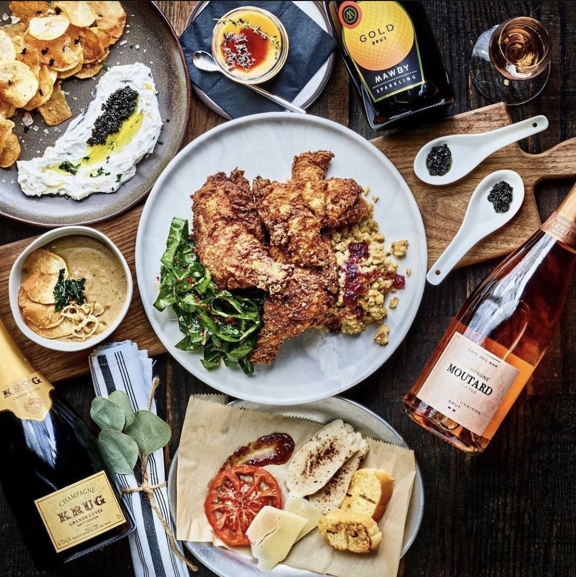 Fried chicken and caviar surrounded by bottles of liquor