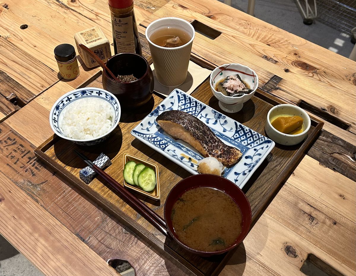 A grilled salmon set with soup, rice, tea, and sides.