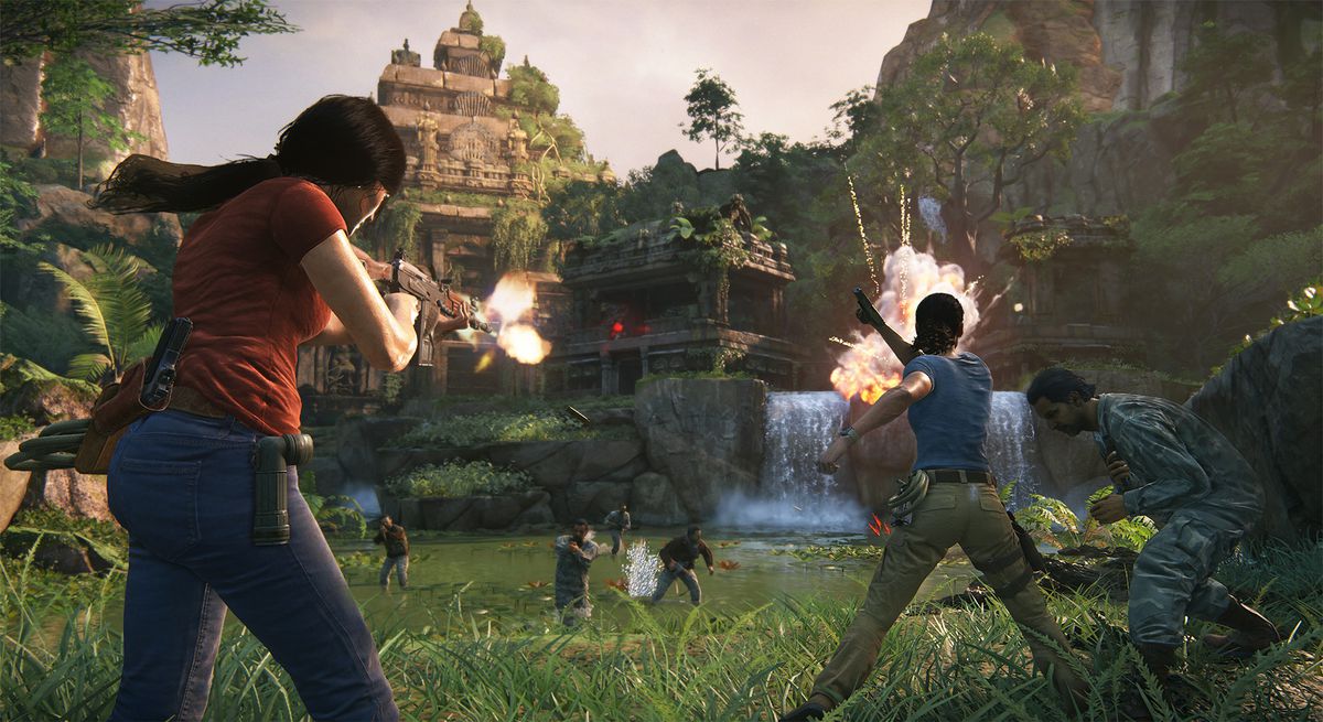 This screenshot from Uncharted: The Lost Legacy shows main characters Nadine and Chloe in the middle of a massive gunfight. Nadine is punching an enemy to one side, while Chloe aims a gun at four other enemies who are approaching through some shallow wate