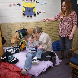 Teacher's aid Fern Wilson and service dog Dopey and teacher Melissa Lovell get Britton Voss up from his nap at school in Clearfield on Monday, Dec. 19, 2016.