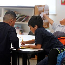 Fatai Palelela, front left, and Jesus Curiel, front right, study at Glendale-Mountain View Community Learning Center in Salt Lake City on Monday, March 7, 2016. At back left is Colleen Lawler of Utah Reads. At back right is Kingston Nusi.