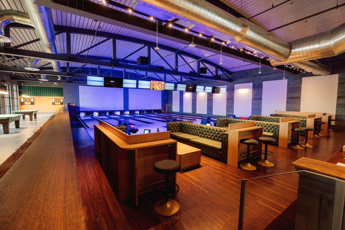 A bowling alley with multiple lanes and booth seating.