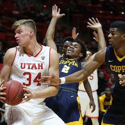 Utah's Jayce Johnson drives into Coppin State's Juwan Davenport (2) at the Huntsman Center at the University of Utah in Salt Lake City on Friday, Nov. 18, 2016.