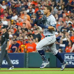 Seattle Mariners center fielder Julio Rodriguez (44) holds on to his batting helmet as he runs to second base after hitting a double in the top of the ninth inning
