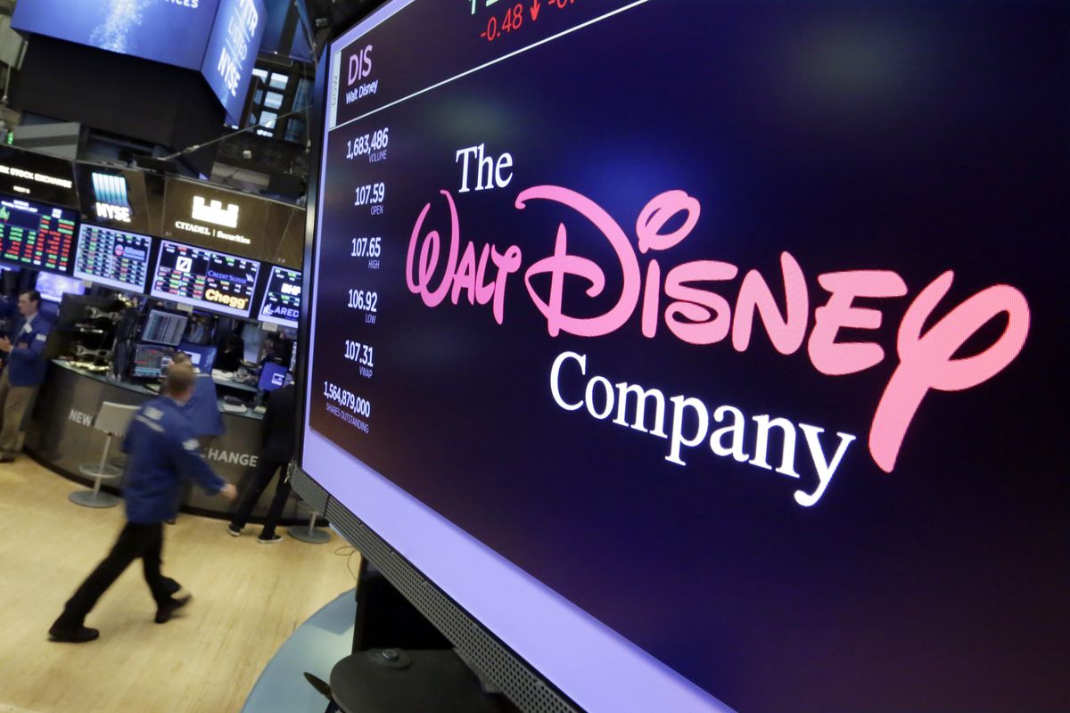 FILE - In this Aug. 8, 2017, file photo, The Walt Disney Co. logo appears on a screen above the floor of the New York Stock Exchange. Disney is buying a large part of the Murdoch family's 21st Century Fox in a $52.4 billion deal, announced Thursday, Dec. 