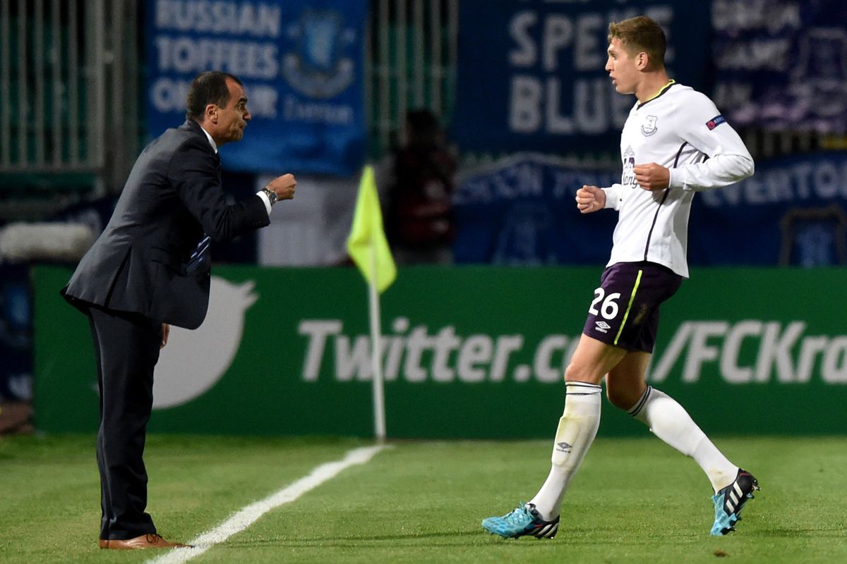 Roberto Martinez gives direction to John Stones during a 2014-15 Europa League match.