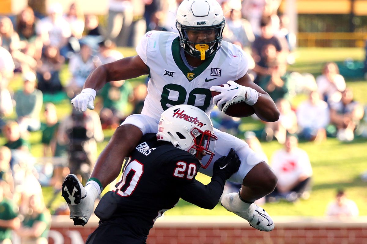 Tight end Drake Dabney #89 of the Baylor Bears tries to leap over defensive back Antonio Brooks #20 of the Houston Cougars in the fourth quarter at McLane Stadium on November 04, 2023 in Waco, Texas.
