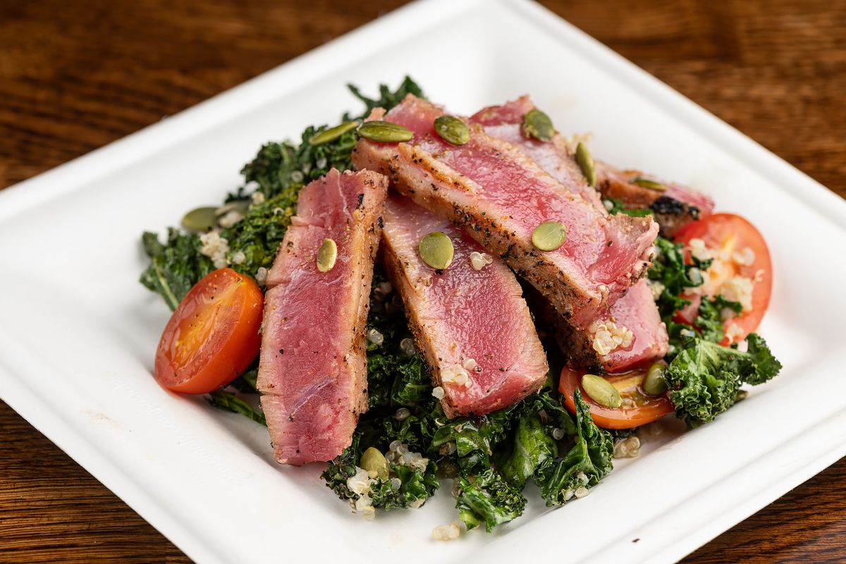 Tuna kale salad with tomatoes on a plate.