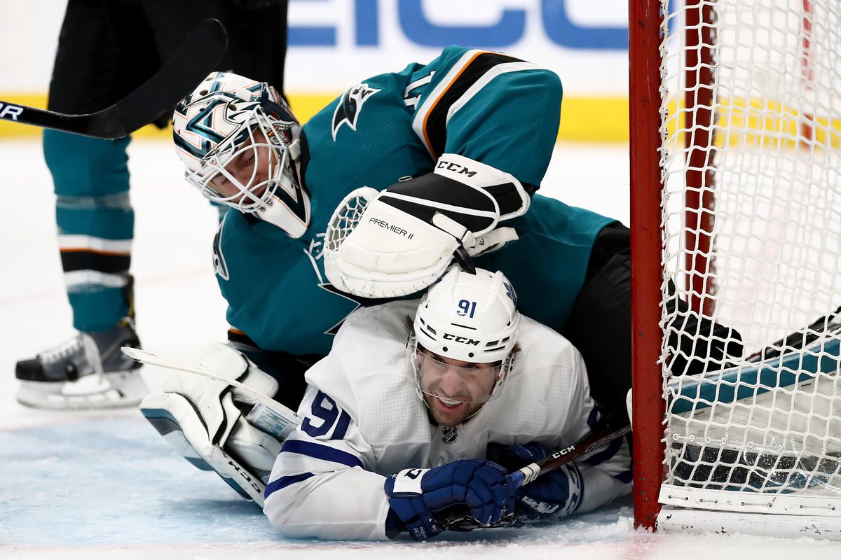 John Tavares #91 of the Toronto Maple Leafs collides with Martin Jones #31 of the San Jose Sharks at SAP Center on March 03, 2020 in San Jose, California.
