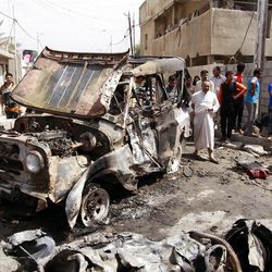 Civilians gather at the scene of a car bombing Monday in the Baghdad neighborhood of Kamaliya, Iraq.  