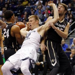 Brigham Young Cougars forward Eric Mika (12) fights for a rebound with Colorado Buffaloes guard George King (24) and forward Lucas Siewert (25) during an NCAA basketball game in Provo on Saturday, Dec. 10, 2016.