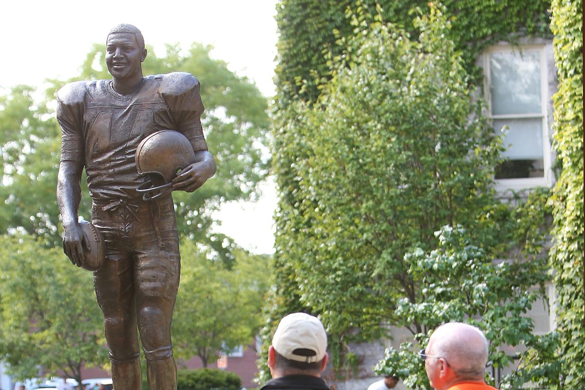 Two Syracuse Orange fans look at the Ernie Davis statue outside of the Carrier Dome before the game against the Stony Brook Seawolves on September 15, 2012 in Syracuse, New York.