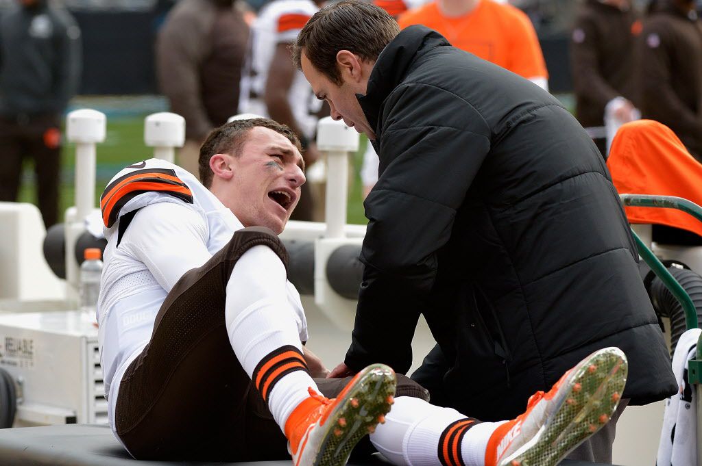A trainer tends to Cleveland Browns quarterback Johnny Manziel after he was injured during their game against the Carolina Panthers. | Grant Halverson/Getty Images