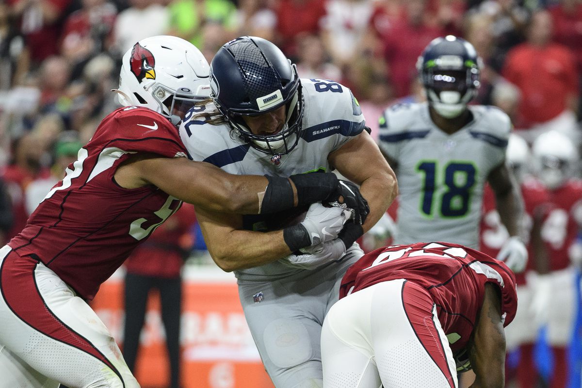 Seattle Seahawks tight end Luke Willson carries the ball against middle linebacker Jordan Hicks and Arizona Cardinals strong safety Budda Baker in the second half of the NFL game at State Farm Stadium on September 29, 2019 in Glendale, Arizona.