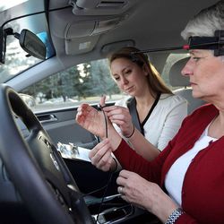 A University of Utah research assistant introduces a participant in new distracted driving studies to special devices designed to gauge mental distraction during road tests.