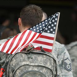 An airman carries an American flag in his backpack after he and more than 200 other airmen in the 34th Fighter Squadron and the 34th Aircraft Maintenance Unit returned to Hill Air Force Base Friday from Bagram Air Base in Afghanistan.