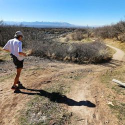 A hiker works his way down a trail in Emigration Canyon as warm temperatures Sunday, Feb. 8, 2015, allow numerous activities from skiing and snowboarding, to golfing, biking and hiking along the Wasatch Front.