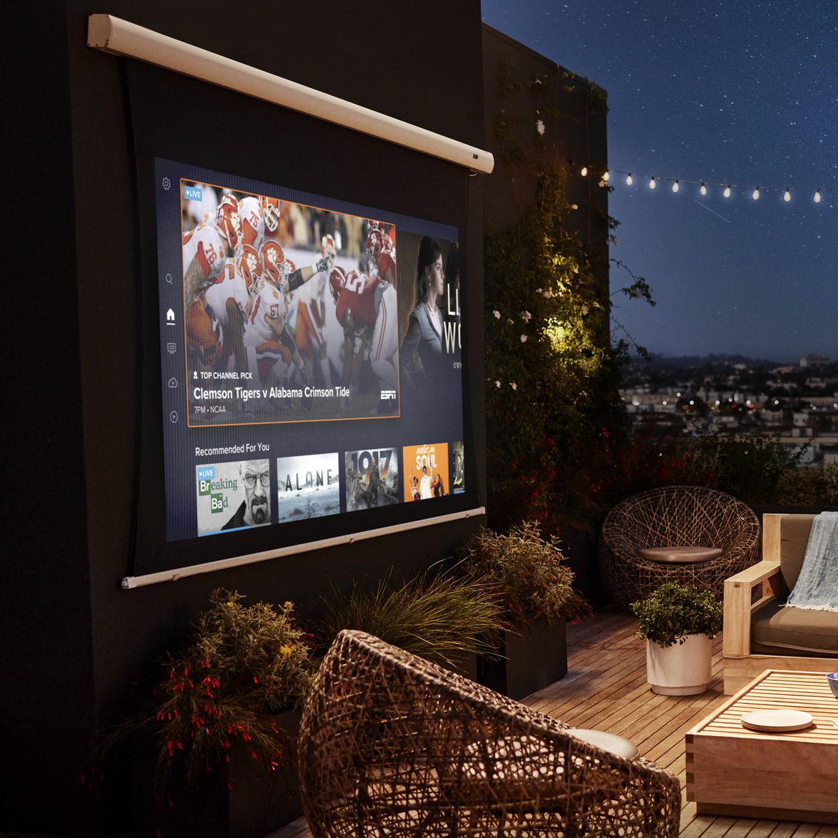 The image shows people watching Sling TV on an outdoor projector screen.