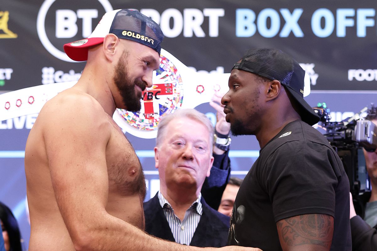 Tyson Fury of Great Britain tickles Dillian Whyte of Great Britain as they face-off during the weigh-in ahead of the heavyweight boxing match between Tyson Fury and Dillian Whyte at BOXPARK on April 22, 2022 in London, England.