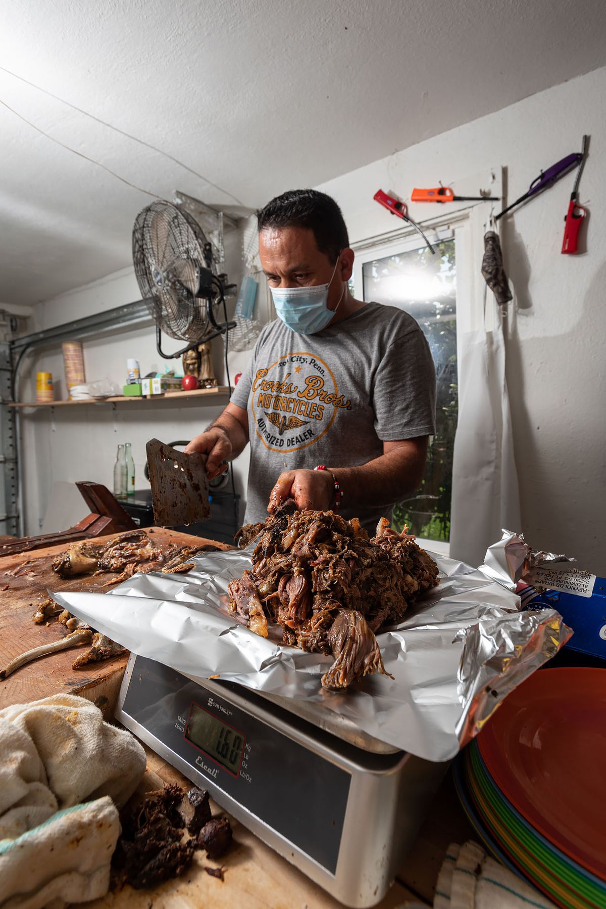 Ramon Coss weighs the barbacoa on a scale.