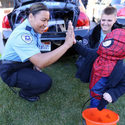 Salt Lake City police explorer Finau Angilau high-fives Iker Tercero, dressed as Spider-Man, at the Utah Foster Care Pumpkin Festival at The Gateway in Salt Lake City on Friday, Oct. 21, 2016.