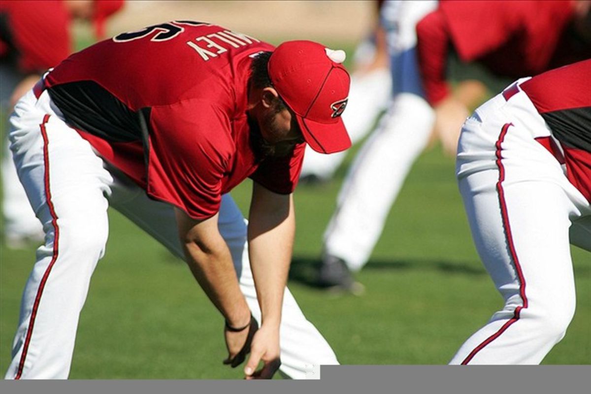 Feb 24, 2012; Scottsdale, AZ, USA; Arizona Diamondbacks starting pitcher Wade Miley (36) stretches with a piece of gum stuck to his hat during spring training at Salt River Fields.  Mandatory Credit: Jake Roth-US PRESSWIRE