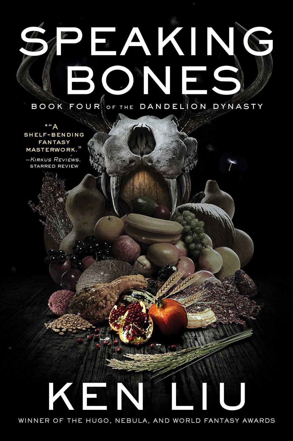 The cover of Speaking Bones by Ken Liu with a cornucopia in front of a garina fin skull.