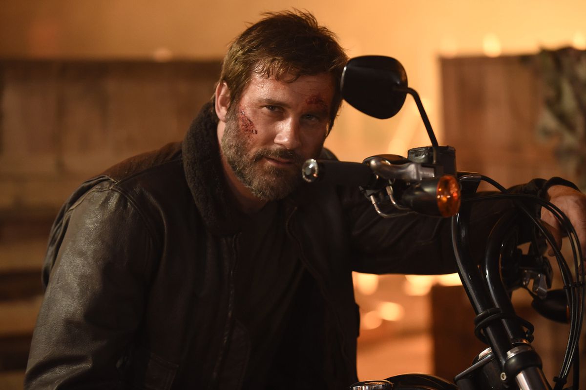 Clive Standen as William Duncan staring behind the handles of a motorcycle in Vendetta
