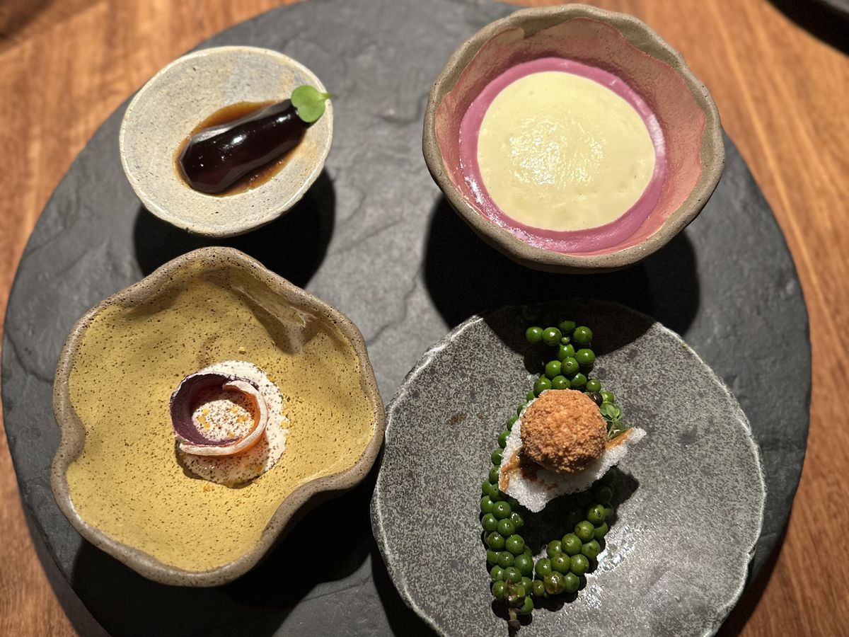 Four small plates presented in decorative ceramic bowls. 
