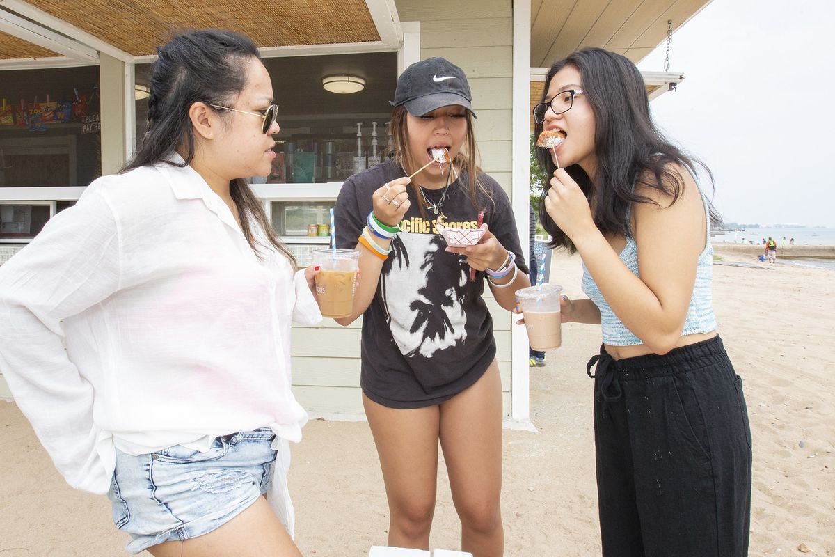 three women eating beignets