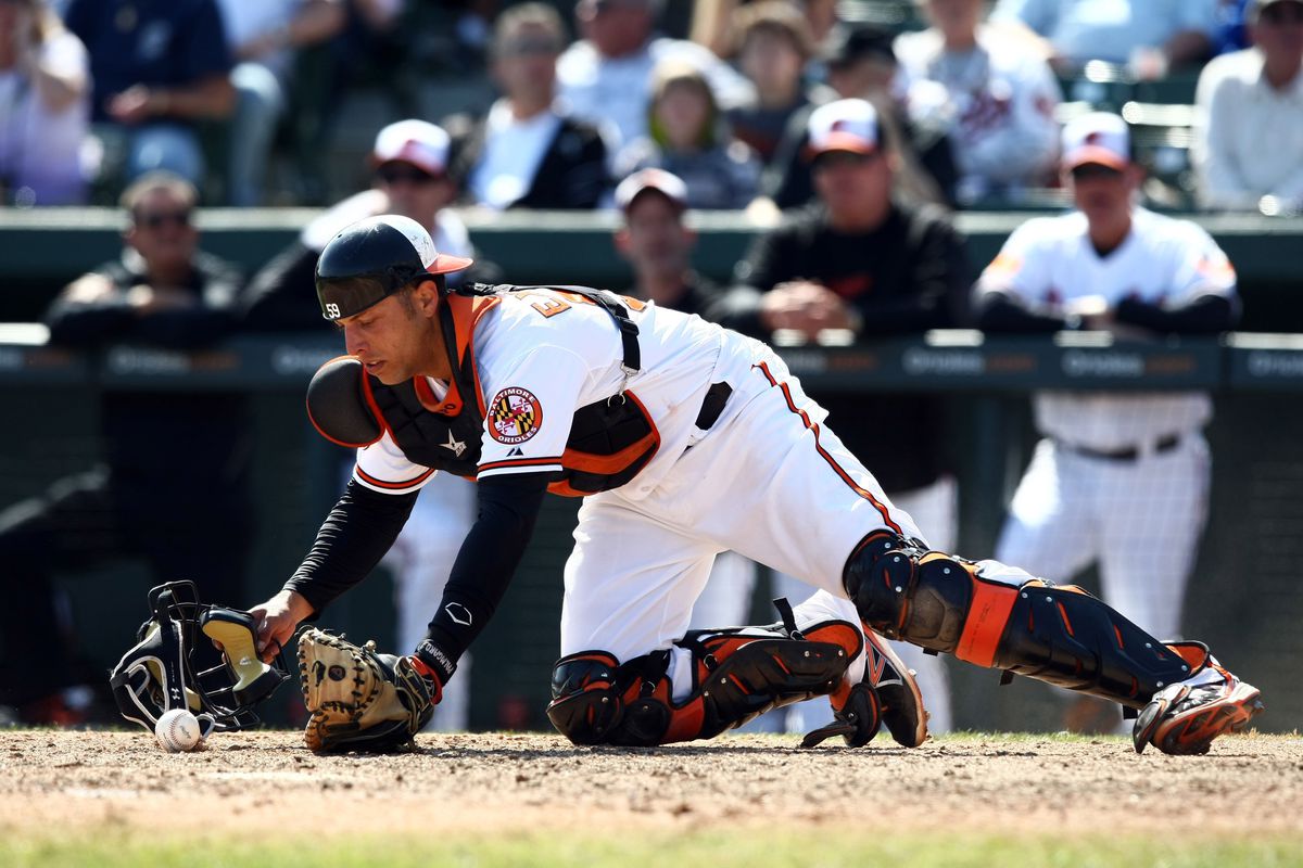 Orioles catcher, Luis Exposito, uses his mask to retrieve a wild pitch. 