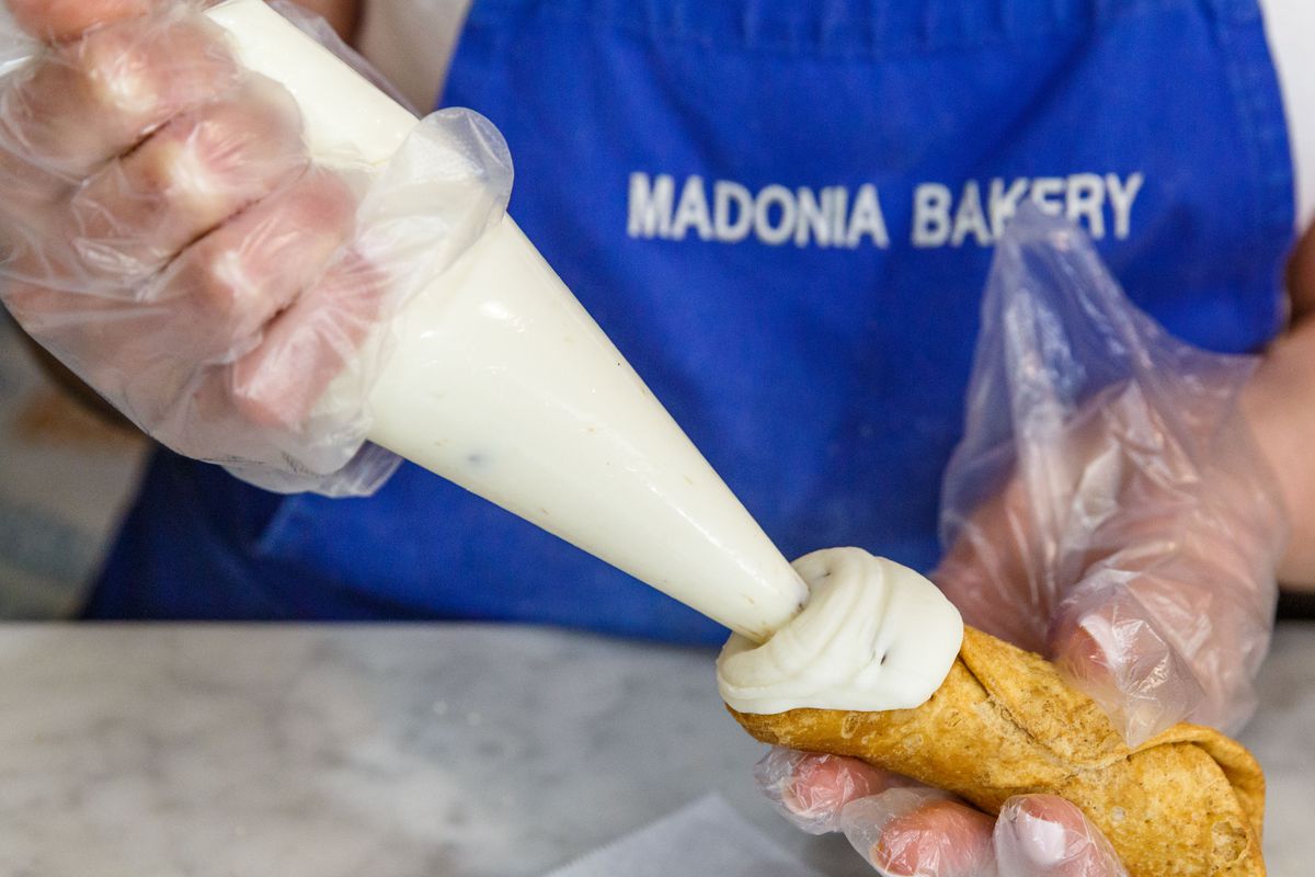 A cannoli being filled at Madonia Brothers Bakery